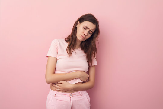 Mulher jovem com apendicite no fundo rosa