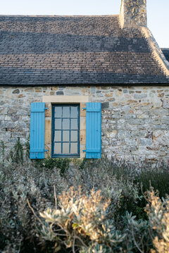 blue window on stone house with shutters in France