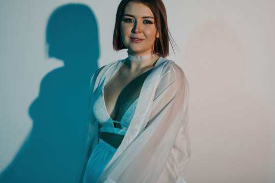 Smiling woman in sensual white lingerie and robe
