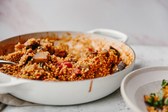 A dish of pearl couscous with tomatoes and aubergine.