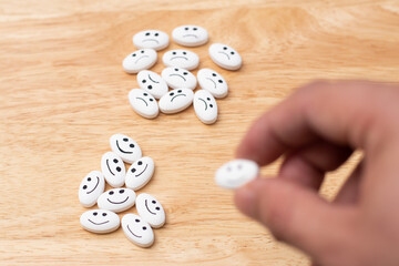 Selective focus in medicine pills over wood table while hand are taking a happy pill