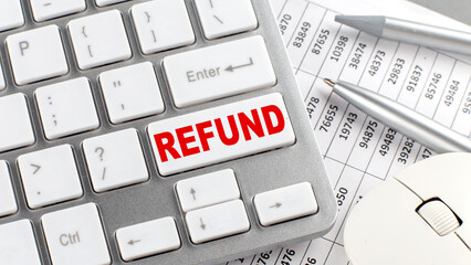 REFUND text on keyboard wirh chart and pencil