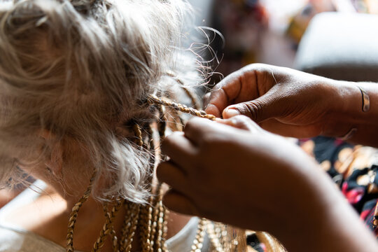 one woman braiding another woman's hair