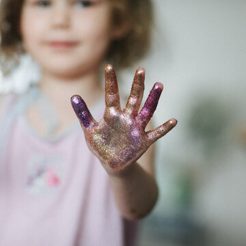 Hand in colorful glitters