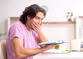 Young male student preparing for exams at home