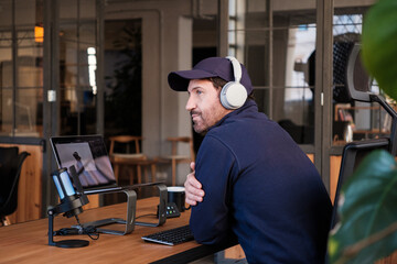 Thoughtful podcaster in streaming with laptop