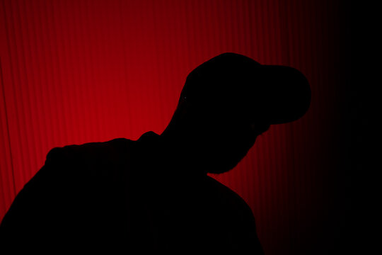 silhouette of unrecognizable man against a background of neon lights