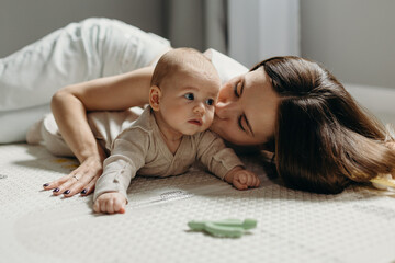 Mother kissing baby son on floor