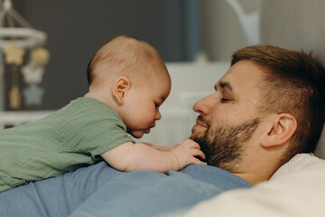 Content man with adorable baby on bed