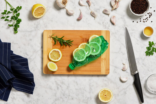Cutting board with plastic bottle and lemon near garlic