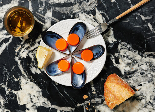 Bottle caps and tins on plate near bread and fork