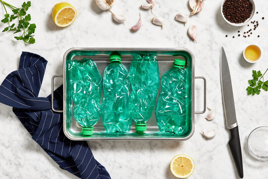 Container of plastic bottles near lemon and garlic