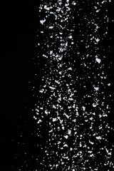 Photo image of falling down snow, heavy big small size snows. Freeze shot on black background isolated overlay. Fluffy White snowflakes splash cloud in mid air. Real Snow high speed shutter
