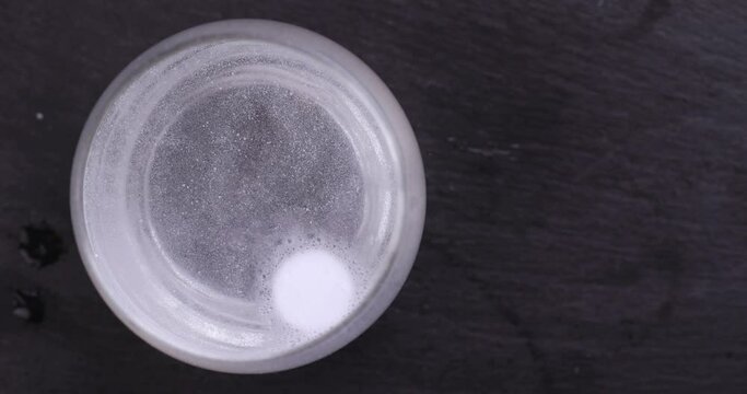 A tablet soluble in a glass of water, a large number of bubbles in the water from a tablet that is dissolved in water