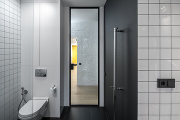 Small modern bathroom with a dark floor, mirror frame, and hardware