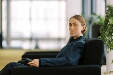  woman wearing man classic suite with  retro cellphone