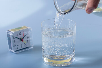 Detail of person filling glass of water. hydration concept