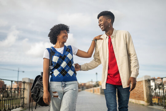 young black couple walking happily in the city