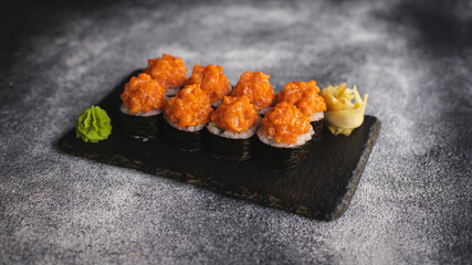 Sushi with wasabi and ginger on a black stone tray on a dark background. Mockup