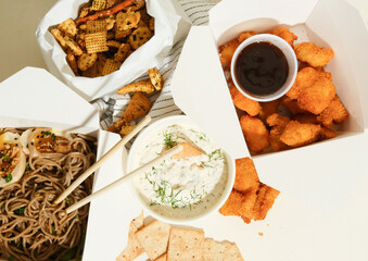 variety of food truck dishes in to-go containers on table