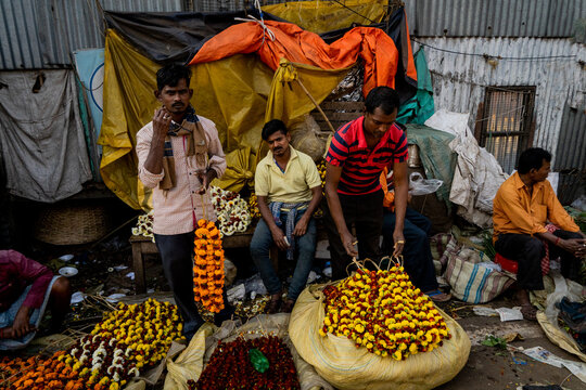 Flower vendors selling bunches of colorful marigolds on the street