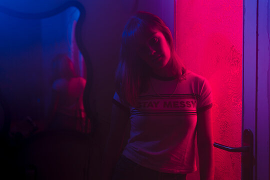 Mysterious woman looking at camera with neon lighting