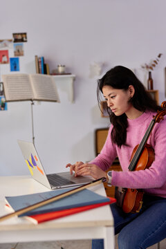 Female violinist during online lesson at home