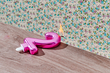 lit number 2 shaped candle