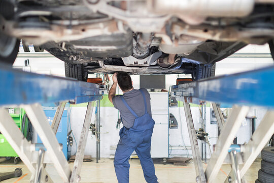 Mechanic Working On Car In Garage