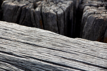 Wooden texture of old wood on the beach. Wooden texture of the surface of the pier. Wooden pier on the background of the sea.Closeup of old weathered wood