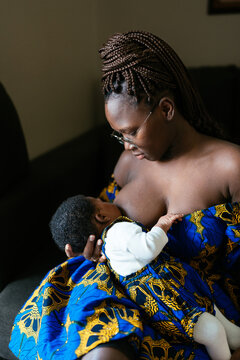 Loving black woman breastfeeding baby