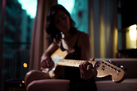 Cinematic close up portrait of woman playing guitar