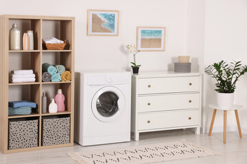 Stylish laundry room with washing machine and chest of drawers. Interior design