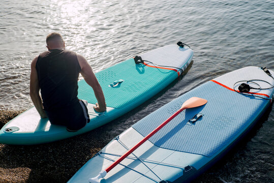 Disabled man with no legs getting ready to walk on Sup board