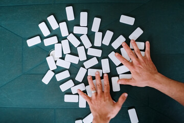 Hands shuffling dominoes on the table