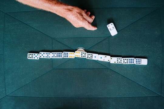 Hand of an old man throwing a domino