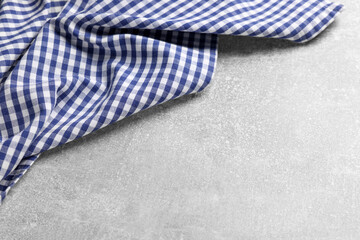 Blue checkered tablecloth on light gray textured table, space for text