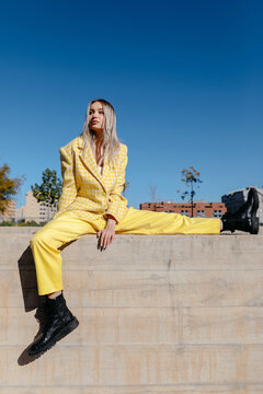 Trendy woman sitting on fence