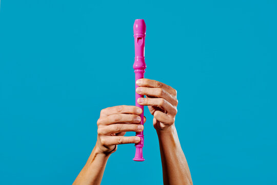 man about to play a pink recorder flute
