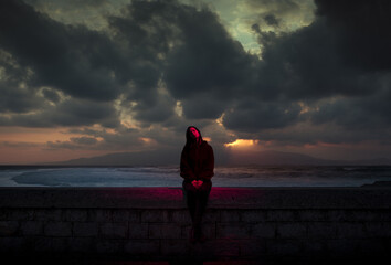 Obraz premium Dramatic portrait of sitting woman under red light