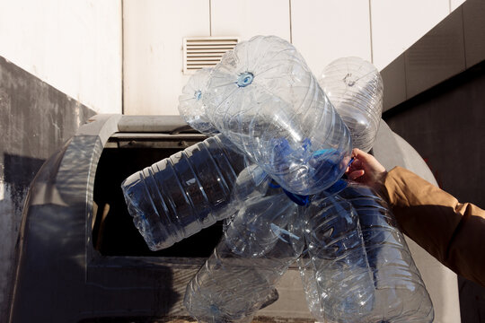 woman throwing away plastic cans