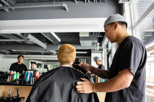 Barber Cuts Hair In Busy Barbershop