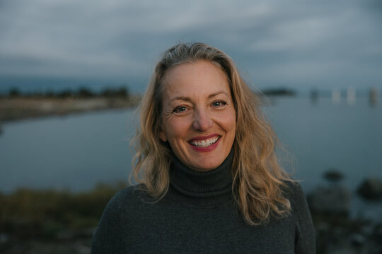 Healthy mature woman looking at the camera for sunset portrait.
