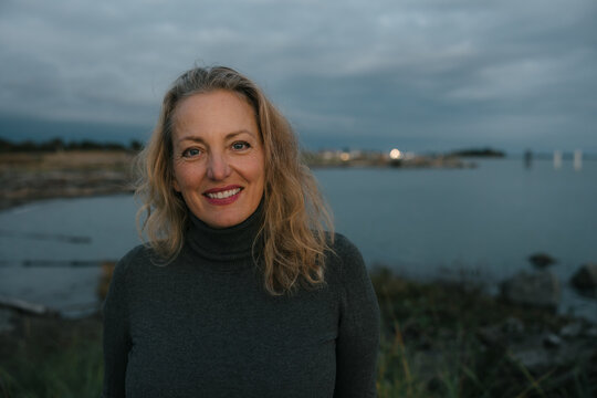 Healthy mature woman looking at the camera for sunset portrait.