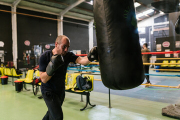 Boxer punching heavy bag with left hand