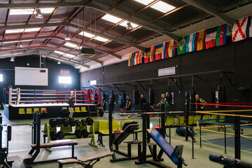 Sportsmen training in spacious gym with boxing rings