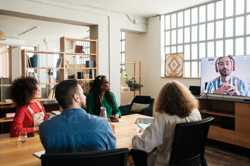 Work team in online meeting from office