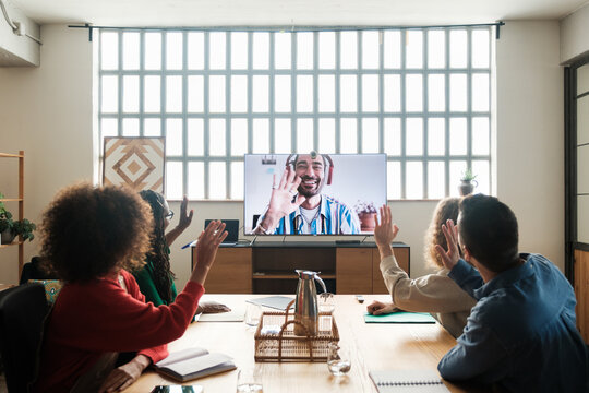 Work team greeting in video call at office