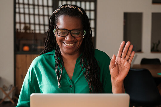 Smiling woman waving hand in Video Conference