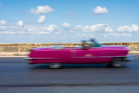 Antique Pink Car Driving On A Malecon Highway